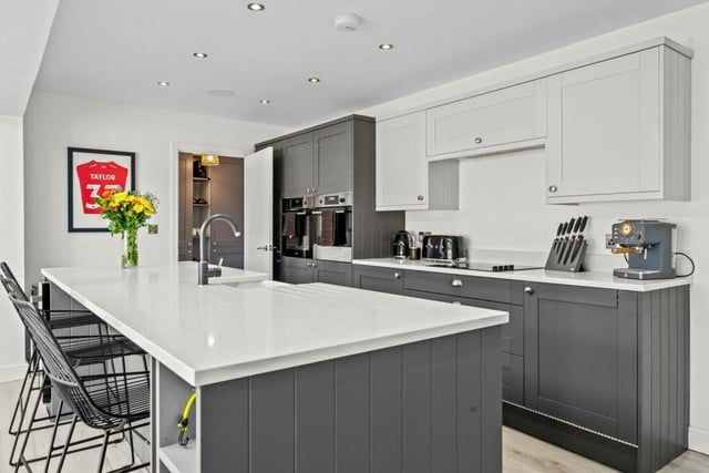 Among the modern kitchen's assets are an island, an integrated double oven, other high-spec integrated appliances, quartz worktops, an induction hob, a Belfast sink and a dishwasher.