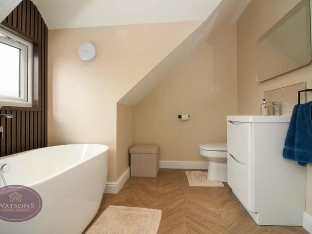 A second glance at the family bathroom. As well as the bath, a four-piece suite in white consists of a shower cubicle, wall-mounted sink and WC. A heated towel-rail and ceiling spotlights add to the room's merit.