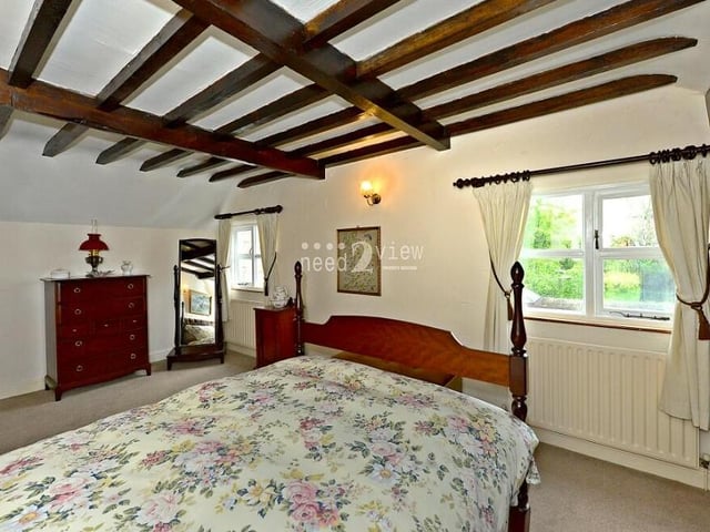 Thanks to windows at the side and front of the cottage, plus plenty of space all round, the second bedroom is bright and airy.