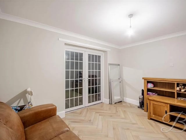 The second sitting room has herringbone flooring, central heating radiator, and patio doors to the rear.