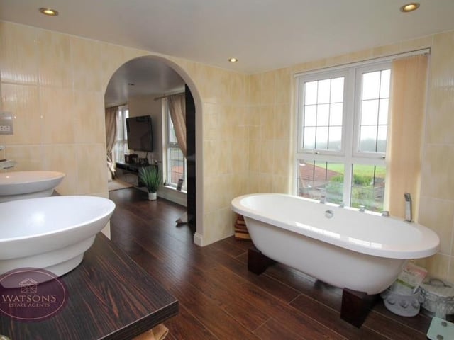 The en suite bathroom to the primary bedroom on the second floor has a certain charm to it. The four-piece suite consists of a free-standing bath, shower cubicle, vanity sink unit and WC. There is also a chrome, heated towel-rail, ceiling spotlights and wood-effect laminated floor.