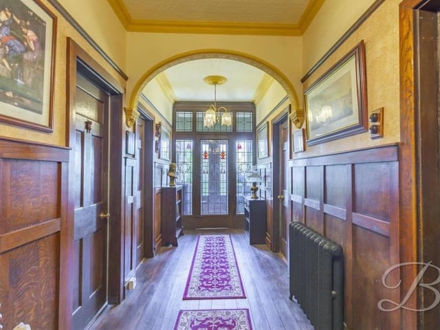 How about this for a spectacular way to start our tour of the Lichfield Lane property? A grand entrance hall with traditional wood panelling, a cast-iron radiator and solid oak flooring.