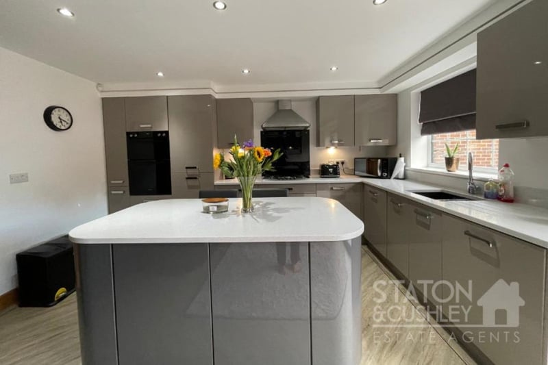 Appliances in the kitchen include an integrated electric double oven, five-piece gas hob with overhead extractor hood, and integrated dishwasher, washing machine and fridge/freezer.