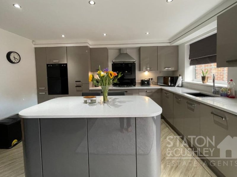 Appliances in the kitchen include an integrated electric double oven, five-piece gas hob with overhead extractor hood, and integrated dishwasher, washing machine and fridge/freezer.