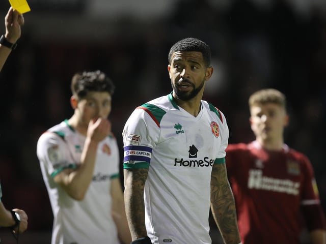 Joss Labadie of Walsall is shown a yellow card.