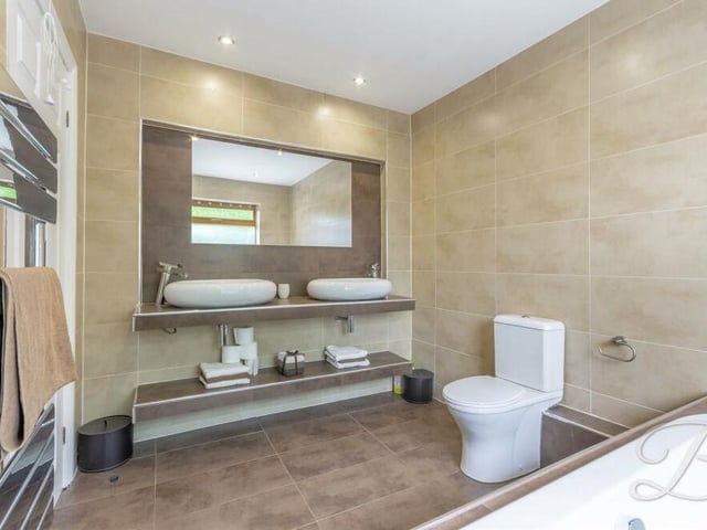 The family bathroom can be found among the myriad rooms on the ground floor. It boasts a fitted bath, low-flush WC, double hand wash basin, chrome, heated towel-rail, downlights and full-height tiling.