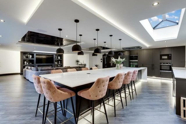 A feature island is a highlight of the kitchen, which is enhanced by recessed spotlights and Karndean flooring.