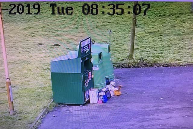 The camera shows rubbish dumped in the car park