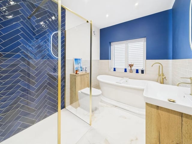 The first floor bathroom is equally impressive, boasting a walk-in shower, a freestanding bath, and brushed brass detailing throughout.
