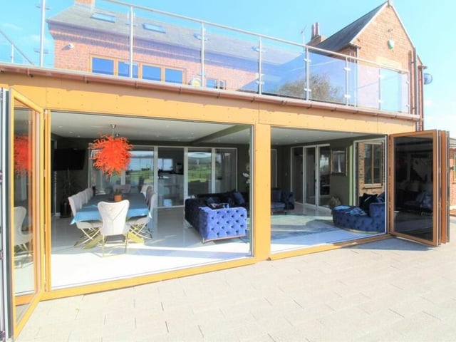 Time to check out a few photos of the exterior of the property now. This one shows how the sun room and dining area open out on to the garden terrace, with the balcony above. A case of fresh air luxury.