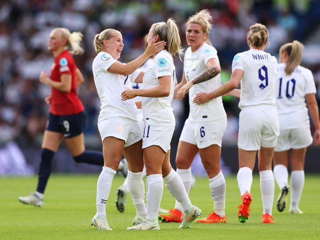Lauren Hemp celebrates with Beth Mead after scoring their team's second goal as Millie Bright looks on.