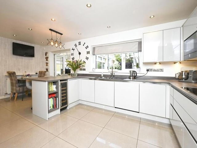 A second shot of the spacious and stylish kitchen. A dining table is in the background towards the left, while a handy utility room is nearby.