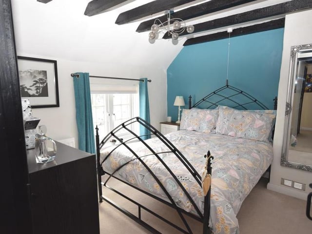 Another lovely double bedroom with beamed ceilings and a window facing the front of the cottage. Other assets include a bank of built-in wardrobes and en suite facilities.