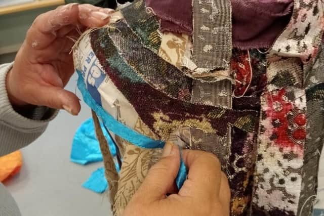 A participant works with fabrics in the Art Power group.