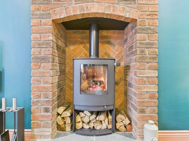 The main lounge is the perfect place for cosy family evenings with a fireplace featuring exposed brickwork and a feature log burner.