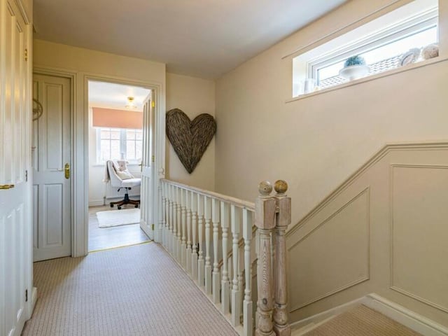 At the top of the staircase is this landing, which has windows to the side and an airing cupboard housing a combination boiler.