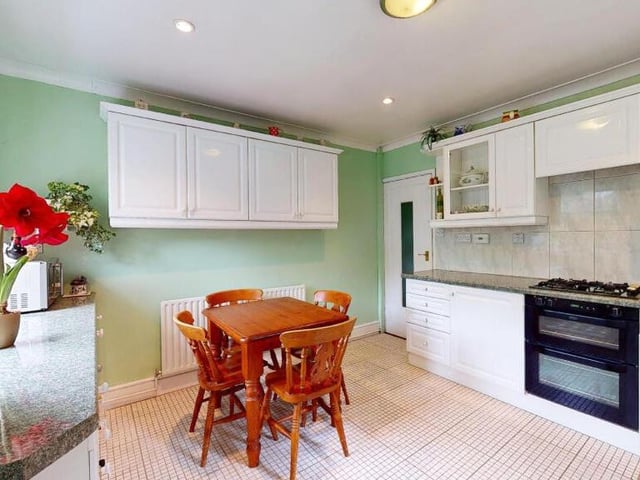 Moving on now to the smart dining kitchen, which is fitted with a range of high-gloss wall and base units, including one with a wine rack, and drawers. As you can see, there is space for a dining or breakfast table, while a ceramic tiled floor adds a touch of style.