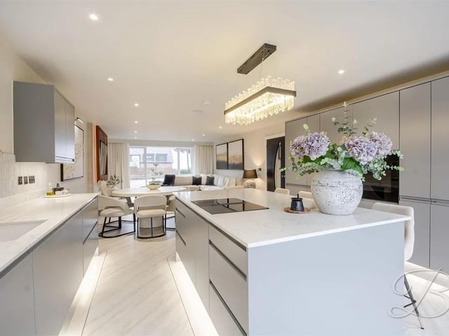 The open-plan kitchen, dining and living area forms a stylish and sociable heart of the home, perfectly suited to modern living.