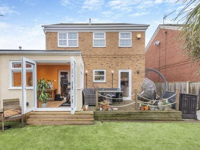 Let;s step outside now, and you can see that the £299,950 property is as handsome from the rear as it is from the front. The French doors swing open from the garden room extension on to a lawn of artificial turf.