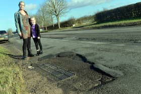 Potholes on Mansfield Road, Clipstone. Tara and six year old Jorje Kay.