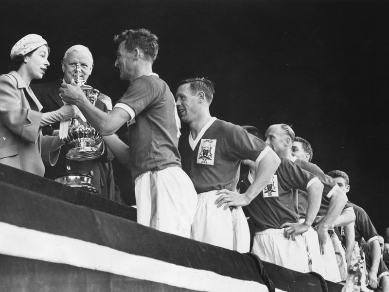Queen Elizabeth II presents the FA Cup trophy to the captain of Nottingham Forest, Jack Burkitt, after their 2-1 victory over Luton Town in the FA Cup final at Wembley.