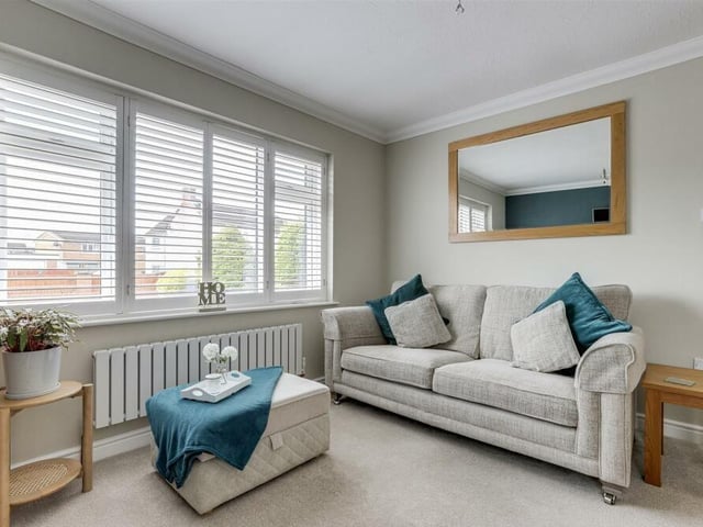 The living room is full of natural light thanks to dual-aspect, double-glazed windows, including this large one facing the front of the property. The windows are fitted with modern, bespoke shutters