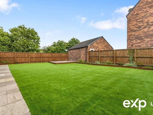 The landscaped rear garden is both generous and low maintenance, with a large patio area, artificial lawn and a charming patio area with pergola overlooking open green space—perfect for outdoor entertaining or peaceful relaxation.