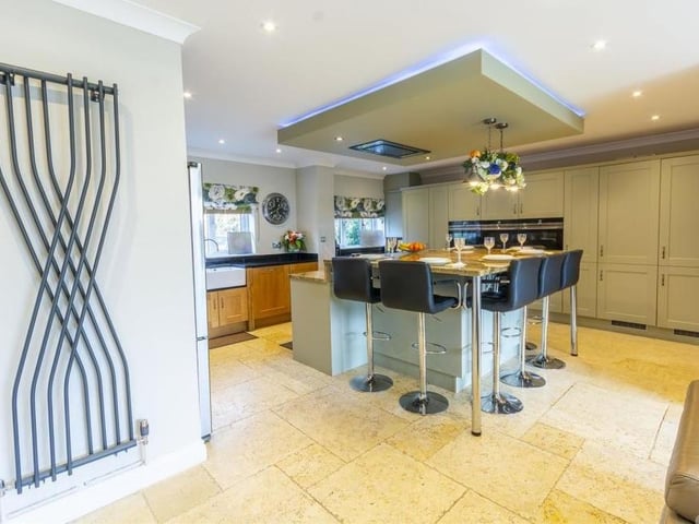 The kitchen also features an island with built-in induction hob and extractor over, and a built-in breakfast table.