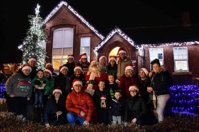 Emma Olden, other volunteers and children with Santa outside a Christmas display at the old council offices in Selston.