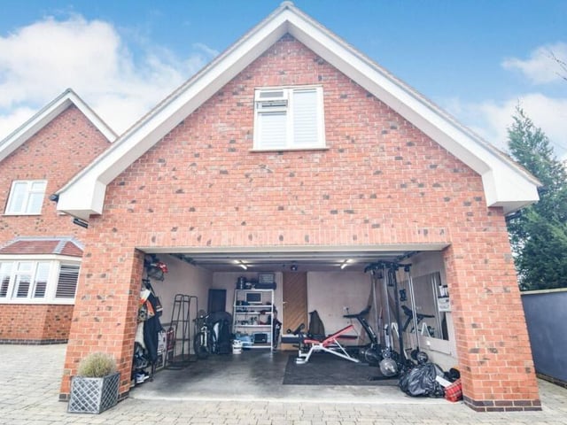 Electric doors open to reveal a large garage that could be put to multiple uses.