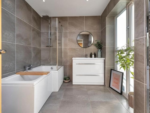 A large, contemporary family bathroom sits on the ground floor. A four-piece suite comprises a panelled bath with chrome mixer tap, a separate shower enclosure with wall-mounted chrome shower, low-flush WC and a wash hand basin set in a vanity unit that contains high-gloss, white storage drawers. There is also a chrome, heated towel-rail, LED spotlights to the ceiling and a large, opaque double-glazed window that lets in plenty of natural light.