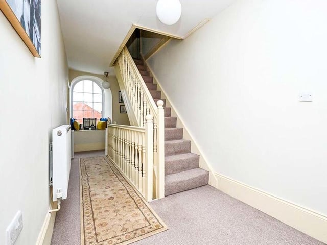 The first-floor landing is a pleasant space. The staircase leads to the second floor, where you will find three more bedrooms,