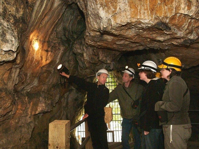 John Charlesworth, Creswell Crags' Principal Heritage Ranger pictured in Robin Hoods Cave with visitors.