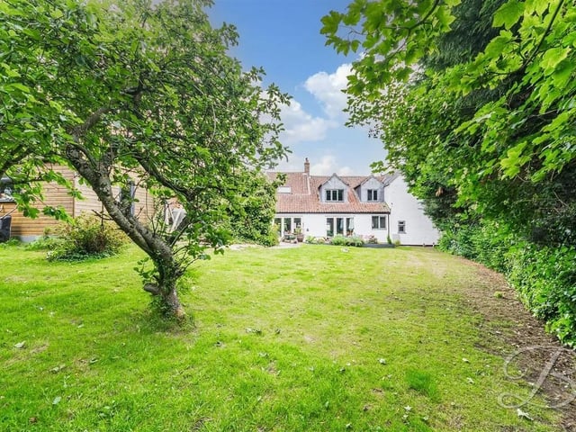 The property boasts a well-kept lawn, surrounded by mature trees and bushes that provide a peaceful and private outdoor setting. Additionally, there is a newly built shed with potential to be converted into a summer house or workspace, along with a separate coal shed.