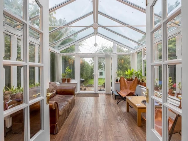This sunlit conservatory oasis is perfect for lounging, reading, or enjoying meals while surrounded by the beauty of the outdoors, regardless of the weather.