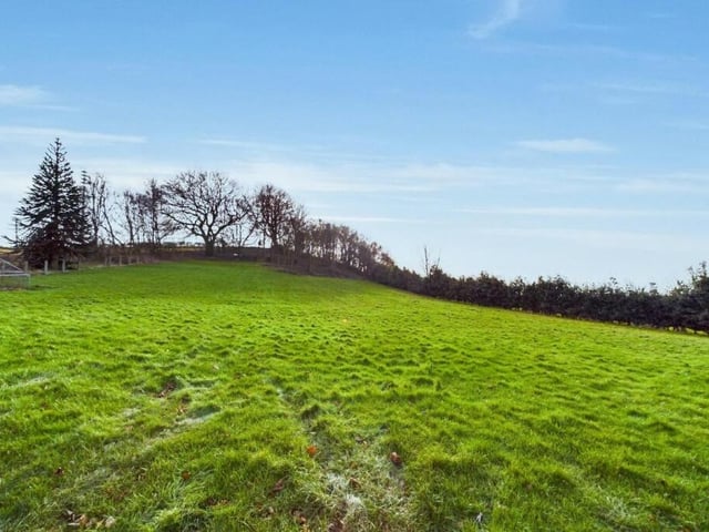 The property sits on a plot of land that stretches to five-and-a-half acres, featuring superb, well-maintained gardens and woodlands.