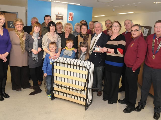 Brian Johnson centre right, presents a Syringe Driver and two beds to staff at Ward 21 at Kings Mill Hospital in memory of his wife Sue, as fellow Lions Club members and family and friends look on back in 2011.