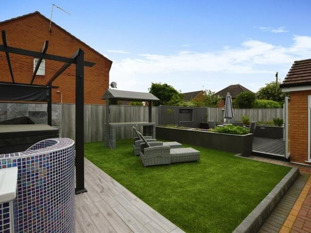 There is lots going on in the back garden, including a hot tub, outdoor TV and outdoor shower.