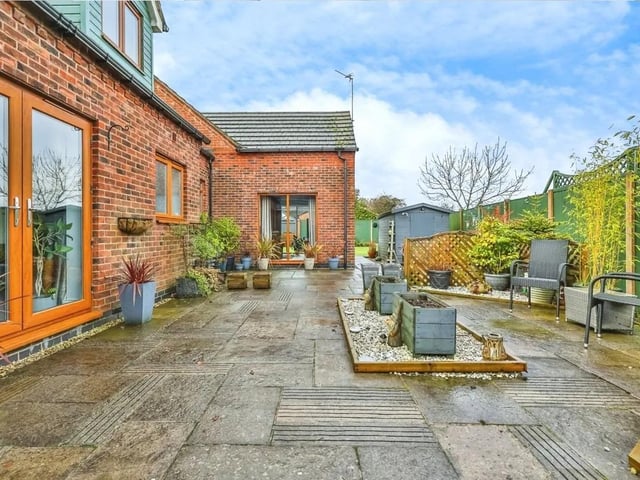 The rear garden features a substantial paved terrace, perfect for family BBQs and alfresco dining.