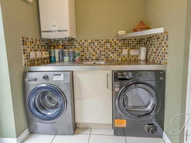 Next to the kitchen is this convenient utility room, which has an additional sink and offers space for a washing machine and tumble dryer.