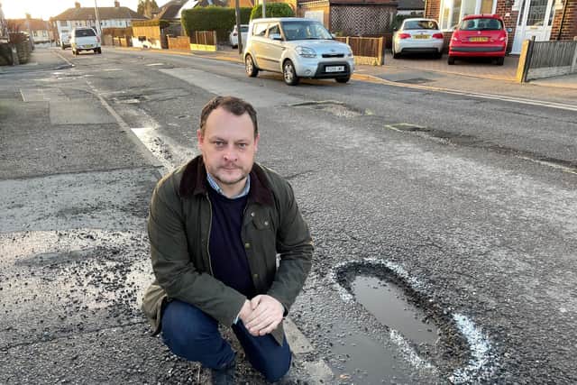 Coun Jason Zadrozny, leader of Ashfield District Council, by one of the many potholes on High Pavement in Sutton.