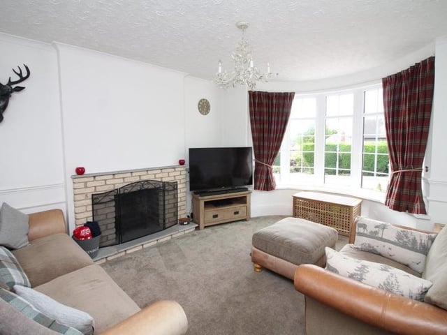 The main reception room on the ground floor of the house is this lovely lounge. Filled with natural light thanks to a uPVC double-glazed bay window facing the front of the property, it boasts an open fireplace.