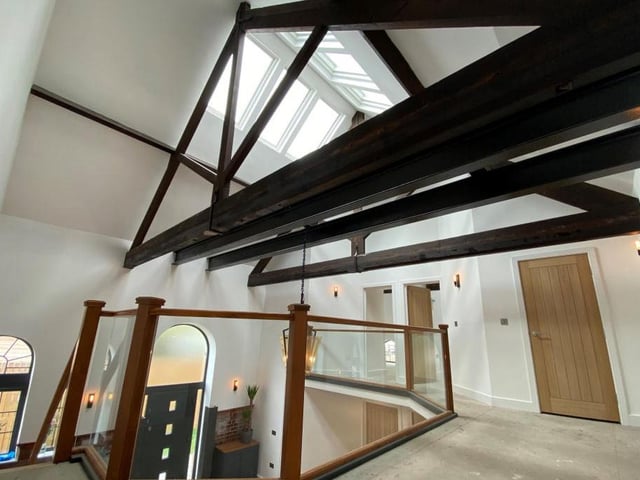 Here is a view of the atrium and the front door from the mezzanine landing. Skylights at roof level cascade natural light down into the space.