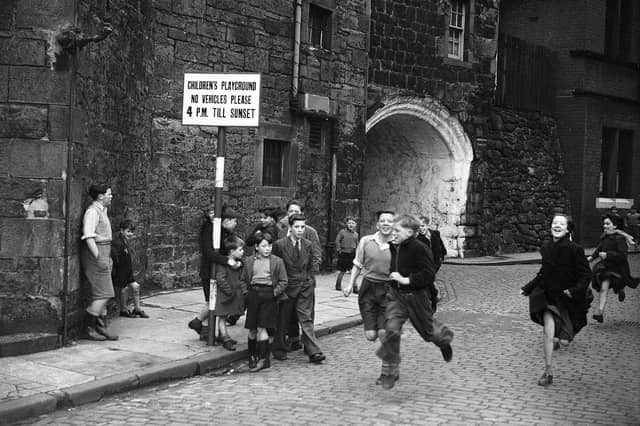Children running on Johnston Street, Leith. Sign shows the street was a designated Children's playground with vehicles banned after 4pm.