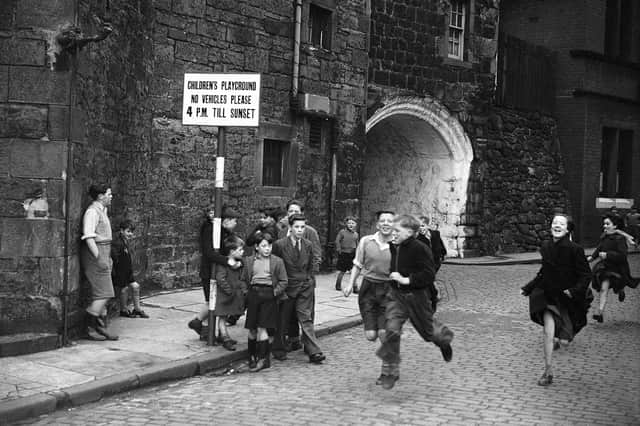 Children running on Johnston Street, Leith. Sign shows the street was a designated Children's playground with vehicles banned after 4pm.