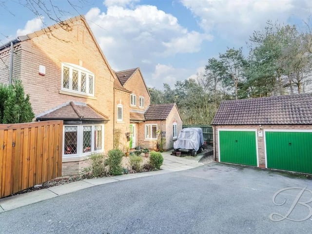 At the front of the property, a large driveway offers ample off-road parking for multiple cars plus a double garage providing space for vehicles and additional storage.