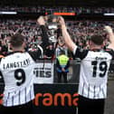Macaulay Langstaff and Cedwyn Scott of Notts County celebrate with the National League Play-Off Final Trophy with fans after their dramatic penalty shoot-out win on Saturday.