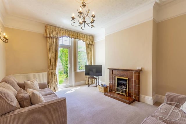 A second shot of the lounge shows its feature fireplace with surround. The room comes complete with a carpeted floor, central heating radiator and double-glazed window.