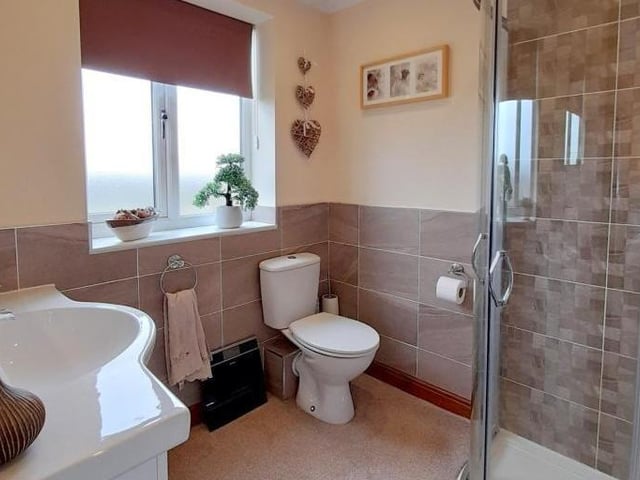 The en suite to the main bedroom offers a shower cubicle, low-flush WC, wash hand basin with cupboard and drawers underneath, and mirror with touch light over. Not to mention coving and recessed spotlights to the ceiling.