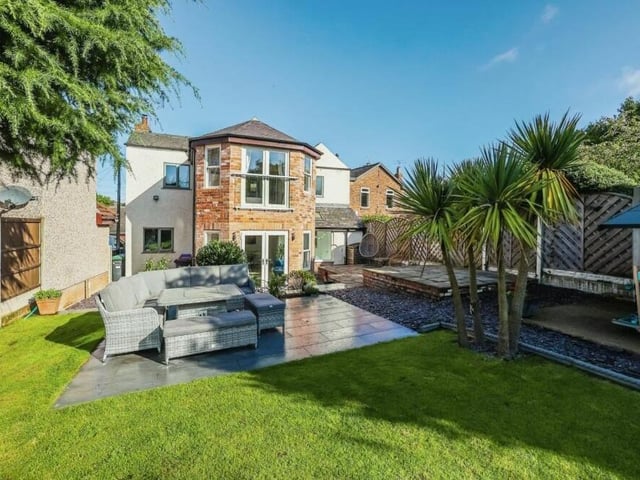 This image was taken from the back garden and gives you a view of the handsome rear of the property, complete with the master bedroom's Juliet balcony and the large ground-floor doors that lead out towards a patio and seating area.